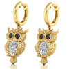 Gold owl-shaped earrings with diamond gemstones on a white background