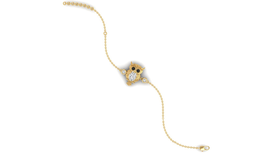 A delicate gold chain bracelet featuring a central owl charm embellished with small clear stones and black eyes, displayed on a solid white background.