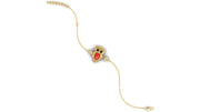 A delicate gold chain bracelet featuring a central owl-shaped charm with red coral gemstone and black eyes, set against a plain white background.