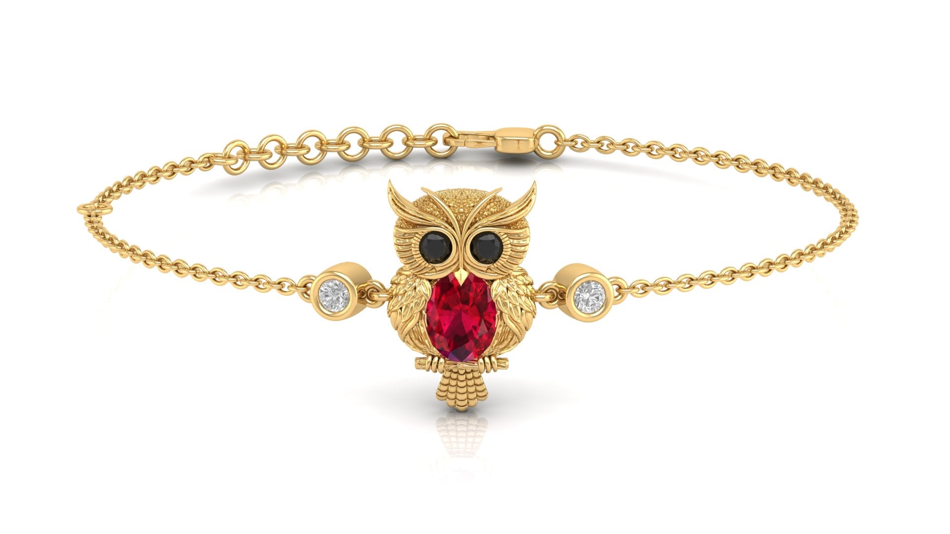 A gold chain bracelet featuring a central owl pendant with a Ruby gemstone, black eyes, and small clear accent stones on either side, shown on a white background.