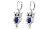 White Gold owl earrings with blue sapphire gemstones on a white background