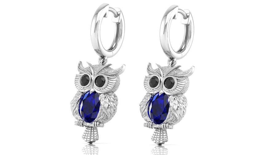 White Gold owl earrings with blue sapphire gemstones on a white background