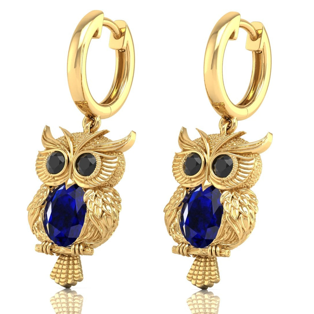 Gold owl-shaped earrings with Blue sapphire gemstones on a white background