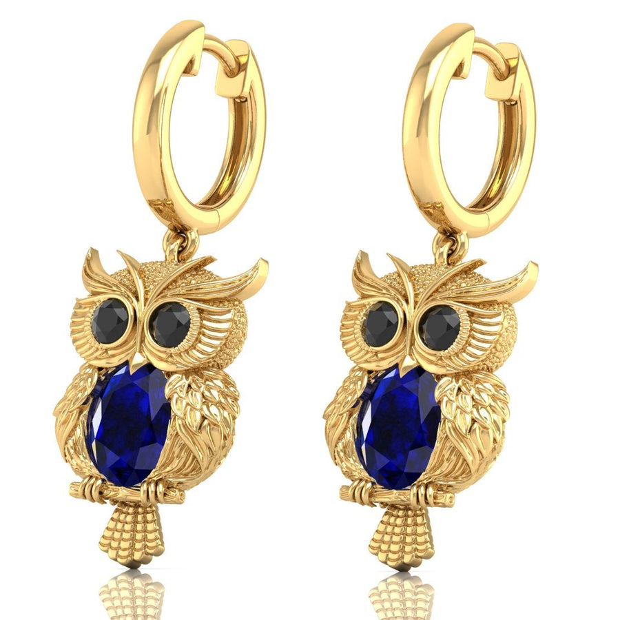 Gold owl-shaped earrings with Blue sapphire gemstones on a white background