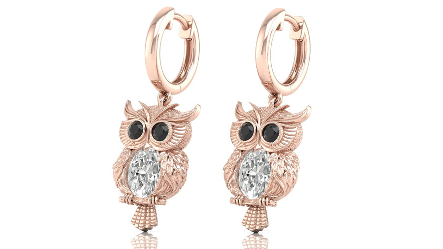 Rose gold owl earrings with diamond gemstones on a white background