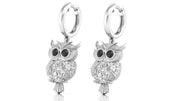 White Gold owl earrings with diamond gemstones on a white background