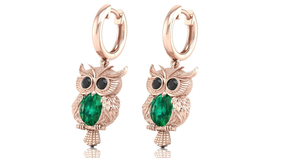 Rose gold owl earrings with green gemstones on a white background