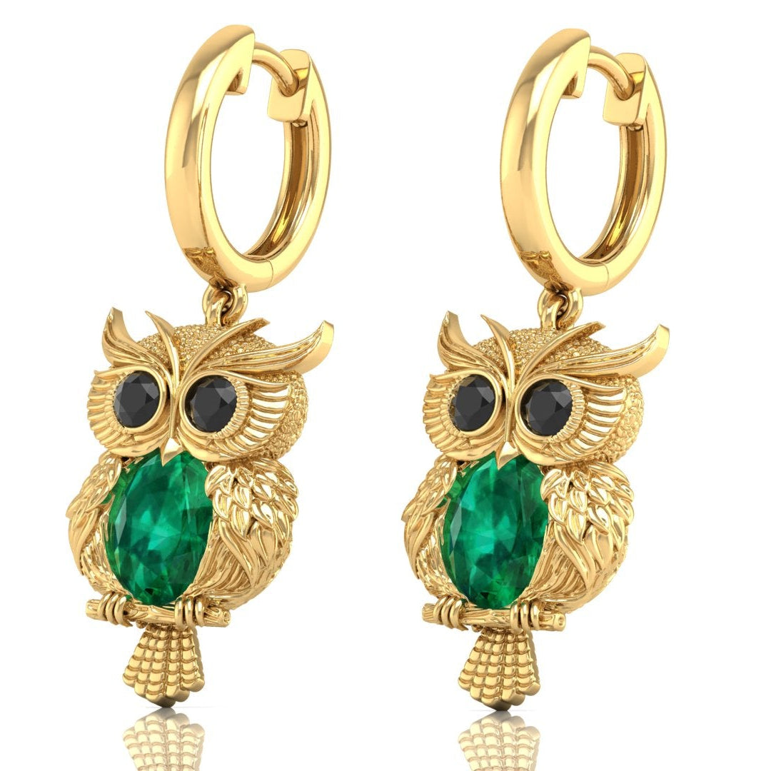 Gold owl-shaped earrings with green gemstones on a white background