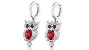 White Gold owl earrings with ruby gemstones on a white background
