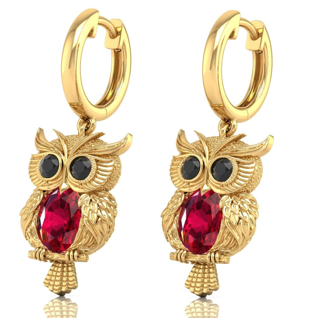 Gold owl-shaped earrings with ruby gemstones on a white background