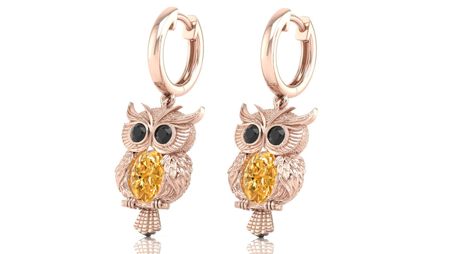 Rose gold owl earrings with yellow sapphire gemstones on a white background