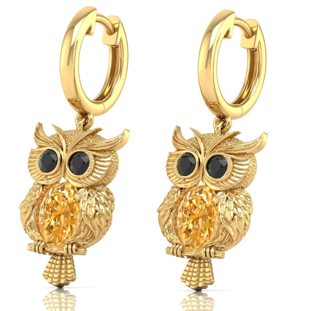Gold owl-shaped earrings with yellow sapphire gemstones on a white background