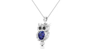 A white gold owl pendant necklace featuring a large dark blue sapphire oval gemstone in its chest, displayed on a clean white background.