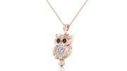 A rose gold owl pendant necklace featuring a large clear oval-cut diamond gemstone in the center and small black gemstone eyes, suspended from a delicate rose gold chain against a white background.