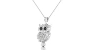 A white gold owl pendant necklace with black-stone eyes and a diamond centrestone, hanging from a delicate silver chain against a plain white background.