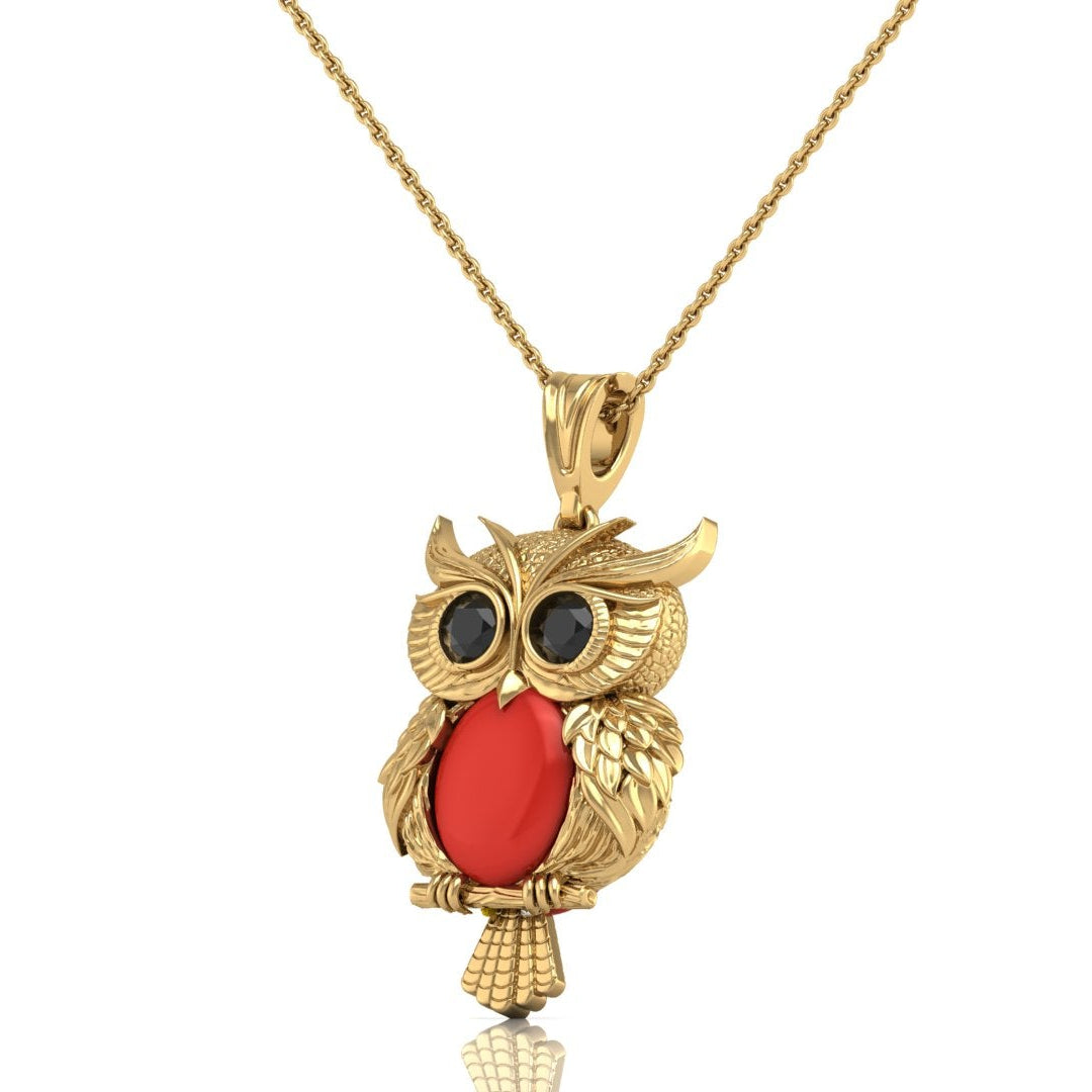 Gold owl pendant necklace with a red coral oval stone and black eye details, shown on a white background with a reflection below.