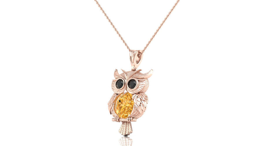 A rose gold owl pendant necklace featuring a large yellow sapphire on the center and black gemstone eyes, shown on a clean white background.
