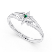 A white gold star ring with a central green emerald and small clear stones, shown on a clean white background. The inside of the band is engraved with 'AUWL ASSEMBLY'.