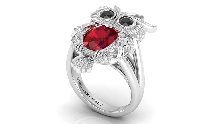 White Gold owl-shaped ring with ruby and black gemstones on a white background