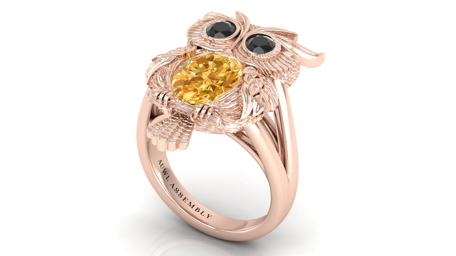Rose gold ring with yellow sapphire and black gemstones on a white background