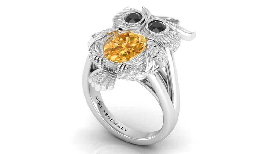 White Gold owl-shaped ring with yellow sapphire and black gemstones on a white background