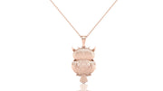 A rose gold pendant necklace featuring an owl design paved with small clear stones, suspended from a delicate matching chain against a solid white background.