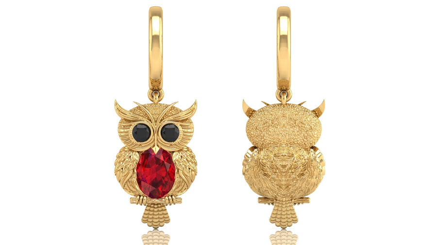 Gold owl-shaped earrings with ruby gemstones on a white background