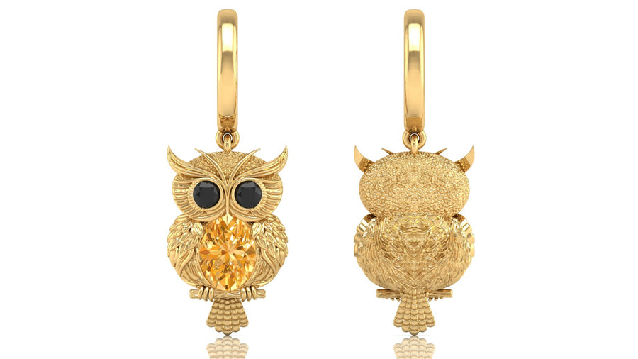 Gold owl-shaped earrings with yellow sapphire gemstones on a white background