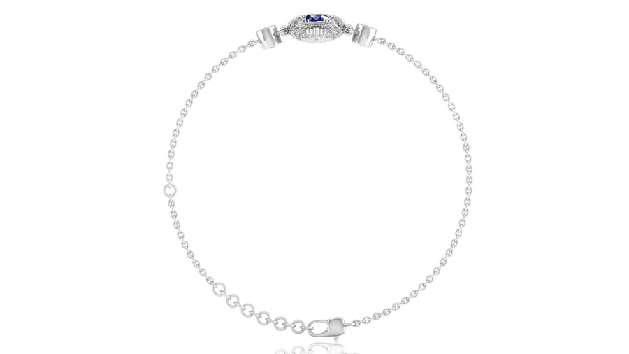 A delicate white gold chain bracelet with a small oval Blue sapphire gemstone centerpiece and clear stones, displayed on a clean white background.