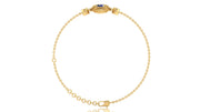 A delicate yellow gold chain bracelet with a safety chain and a decorative clasp featuring a small blue sapphire gemstone, shown on a plain white background.