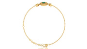 A delicate yellow gold chain bracelet with a decorative oval clasp featuring a green stone, displayed on a clean white background.