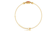 A delicate yellow gold chain bracelet with a decorative oval clasp featuring a red coral gemstone, displayed on a clean white background.