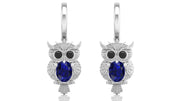 White Gold owl earrings with blue sapphire gemstones on a white background