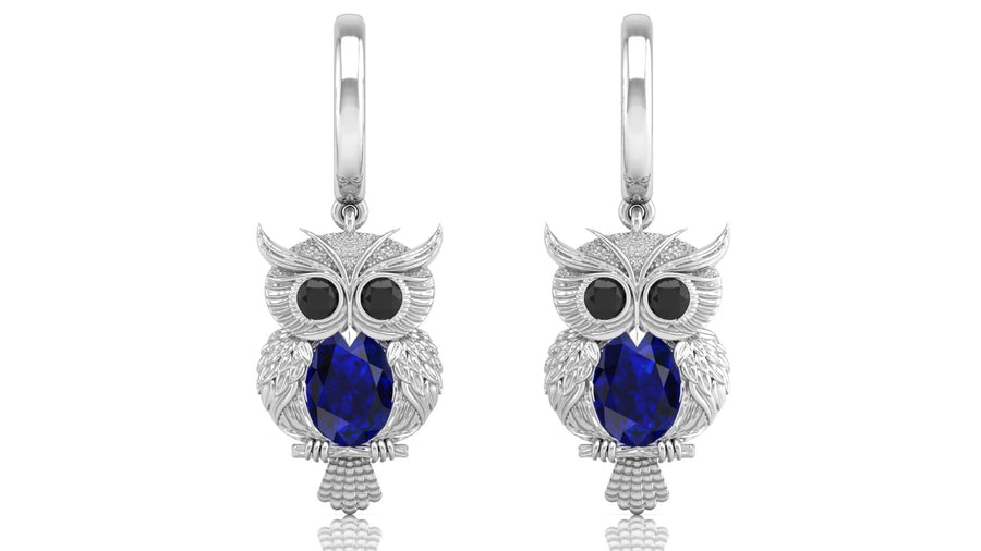 White Gold owl earrings with blue sapphire gemstones on a white background