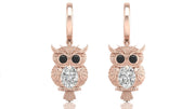Rose gold owl earrings with diamond gemstones on a white background
