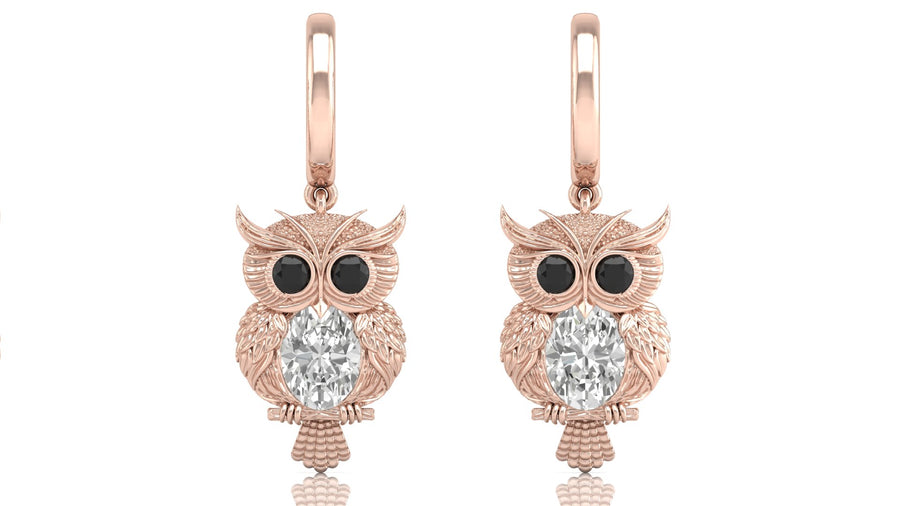 Rose gold owl earrings with diamond gemstones on a white background