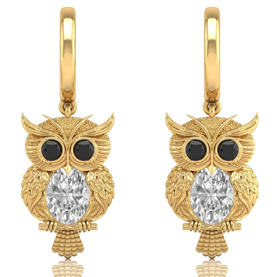 Gold owl earrings with diamond gemstones on a white background