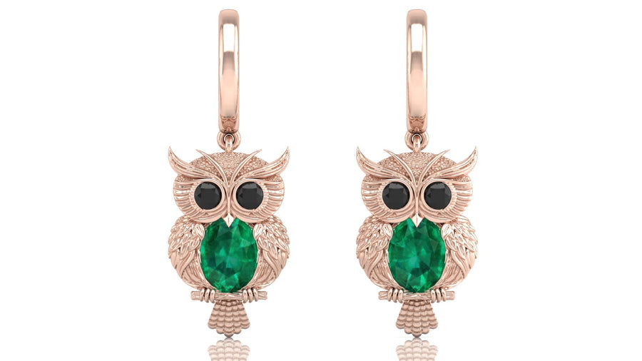 Rose gold owl earrings with green gemstones on a white background