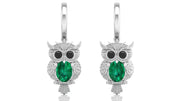 Owl-shaped earrings with green gemstones on a white background