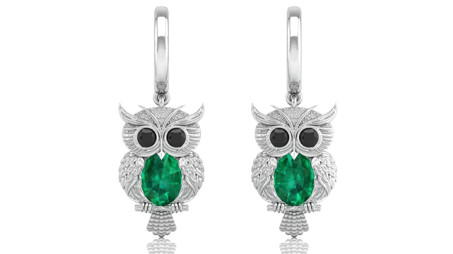 Owl-shaped earrings with green gemstones on a white background
