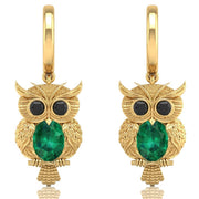 Gold owl earrings with emerald green gemstone on a white background