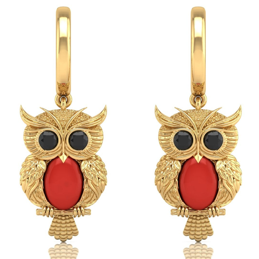 Gold owl earrings with red coral gemstones on a white background