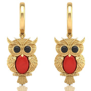 Gold owl earrings with red coral gemstones on a white background