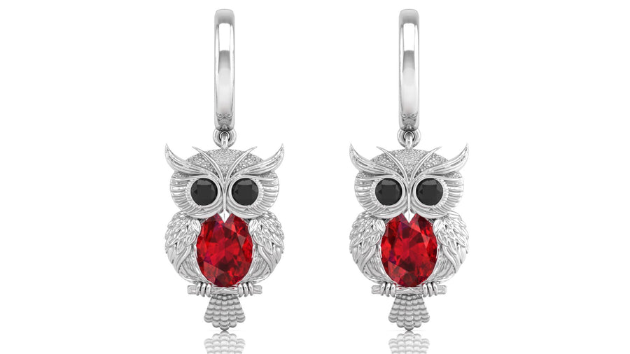 White Gold owl earrings with ruby gemstones on a white background