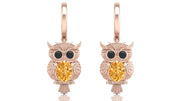 Rose gold owl earrings with yellow sapphire gemstones on a white background