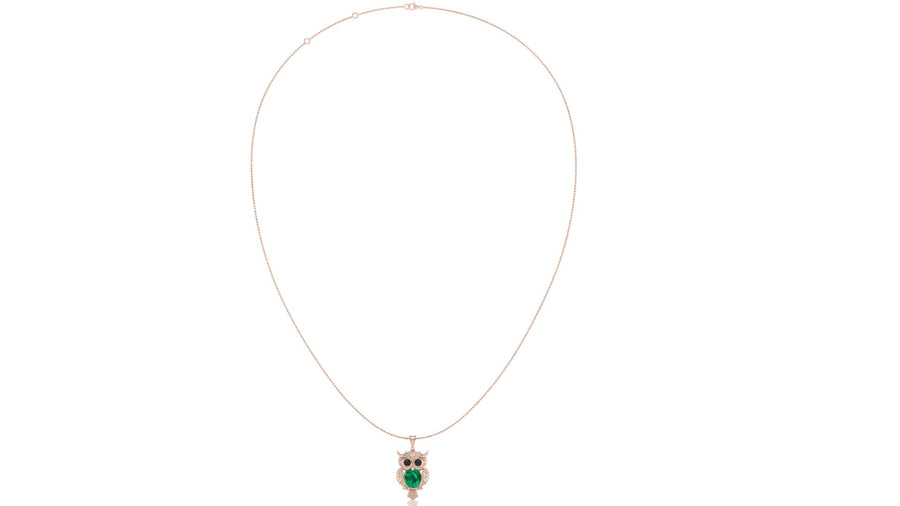 A delicate rose gold chain necklace featuring an owl pendant with a green emerald center and black eyes, displayed against a solid white background.