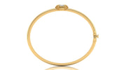 A yellow gold hinged bangle bracelet with a decorative floral crown clasp at the top, shown on a plain white background with a subtle reflection.