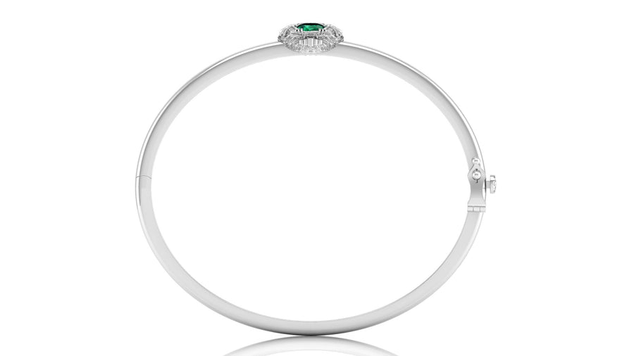 A polished white gold bangle bracelet with a small oval green gemstone and surrounding clear stones at the top, shown on a plain white background.