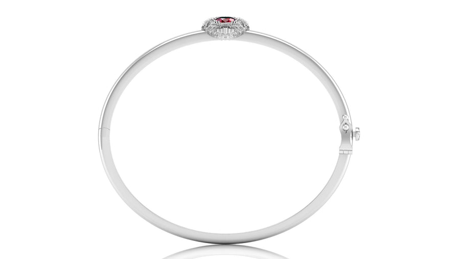 A polished white gold bangle bracelet with a small oval red ruby gemstone at the top, shown on a plain white background.