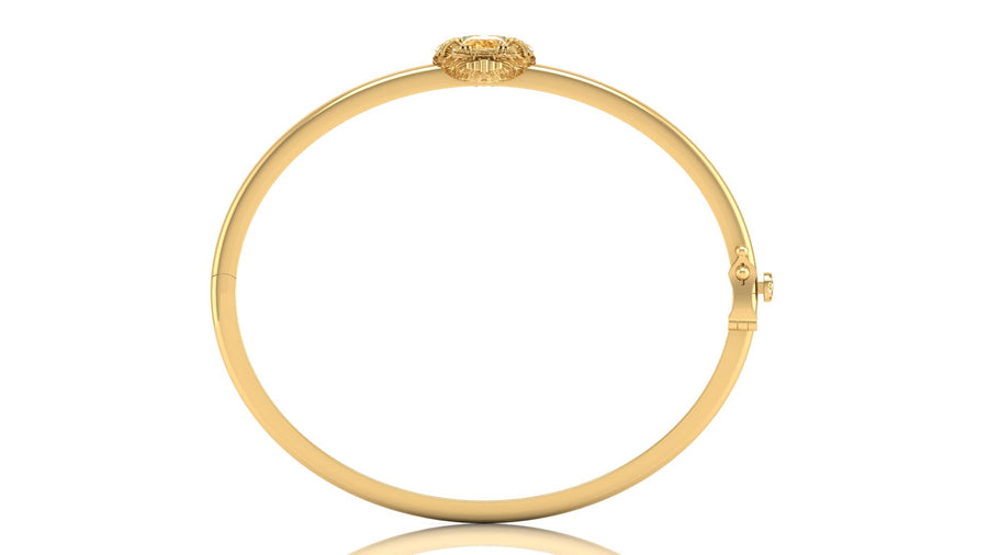 A yellow gold hinged bangle bracelet with a yellow sapphire gemstone at the top, shown on a plain white background with a subtle reflection.